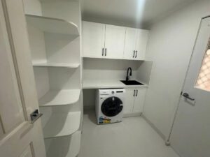 Laundry with cabinets in white colour
